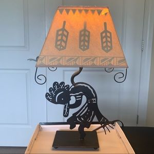 Kokopelli design metal lamp with paper shade & black arrowhead design when on.
